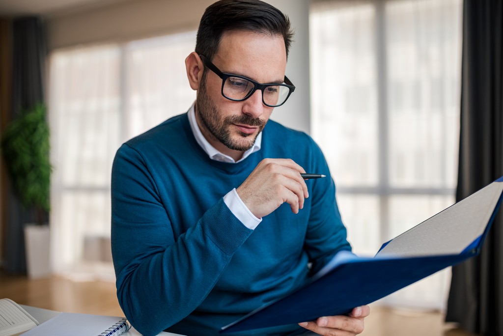 Advisor with glasses reviewing documents in a folder